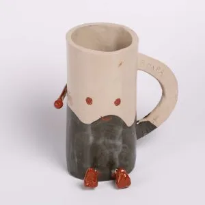 Mug en céramique avec visage et petits bras, décoré à la main par un participant à l’atelier