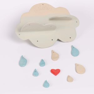 Mobile décoratif en céramique en forme de nuage, avec des gouttes colorées et un petit cœur rouge, création artisanale lors d’un atelier