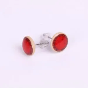 Vue rapprochée de la paire de boucles d’oreilles puce en porcelaine Rouge Feu, détail de la couleur éclatante et de l’émail artisanal.