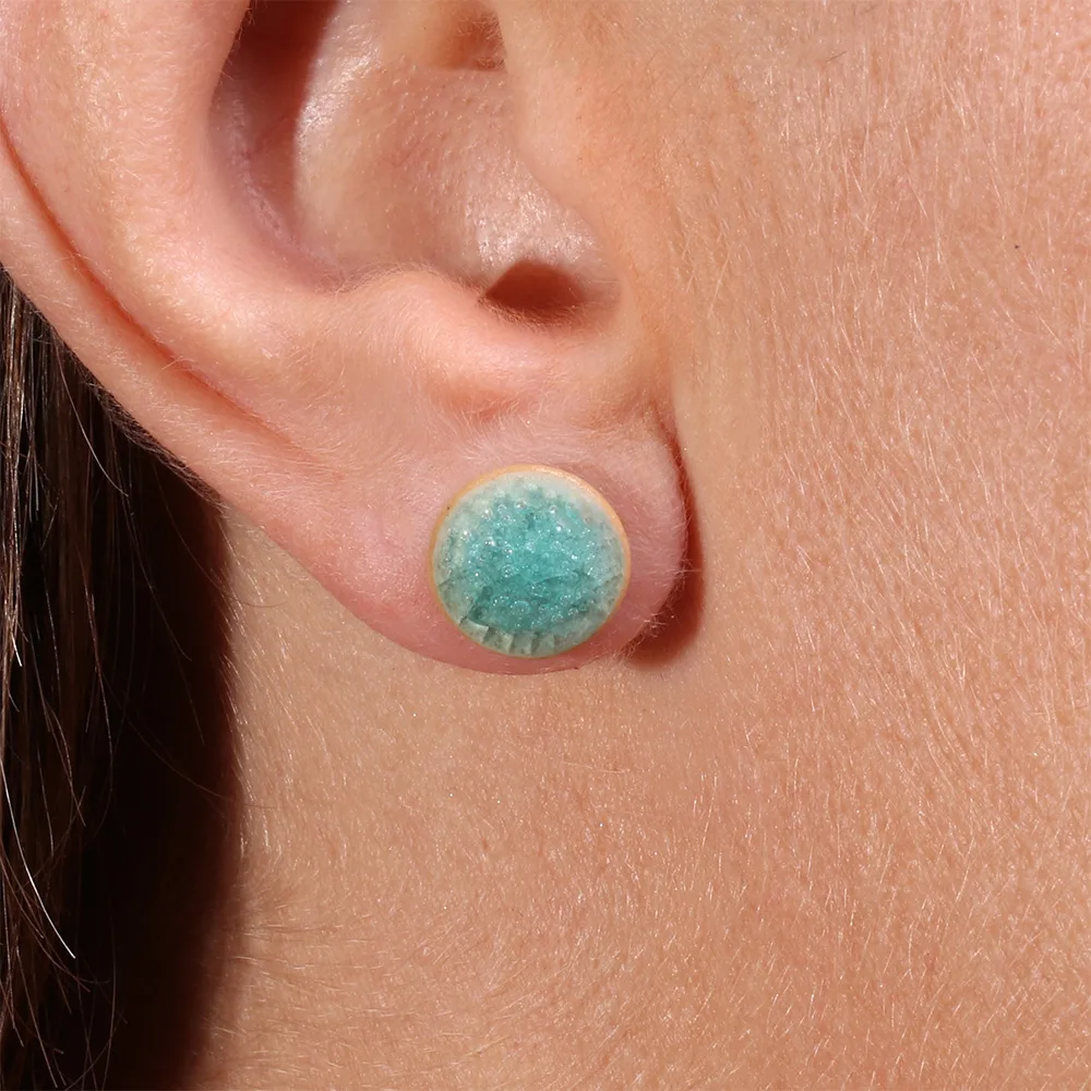 Gros plan sur la boucle d’oreille puce Reflets d’Océan Turquoise Lagune, détail des reflets émaillés.