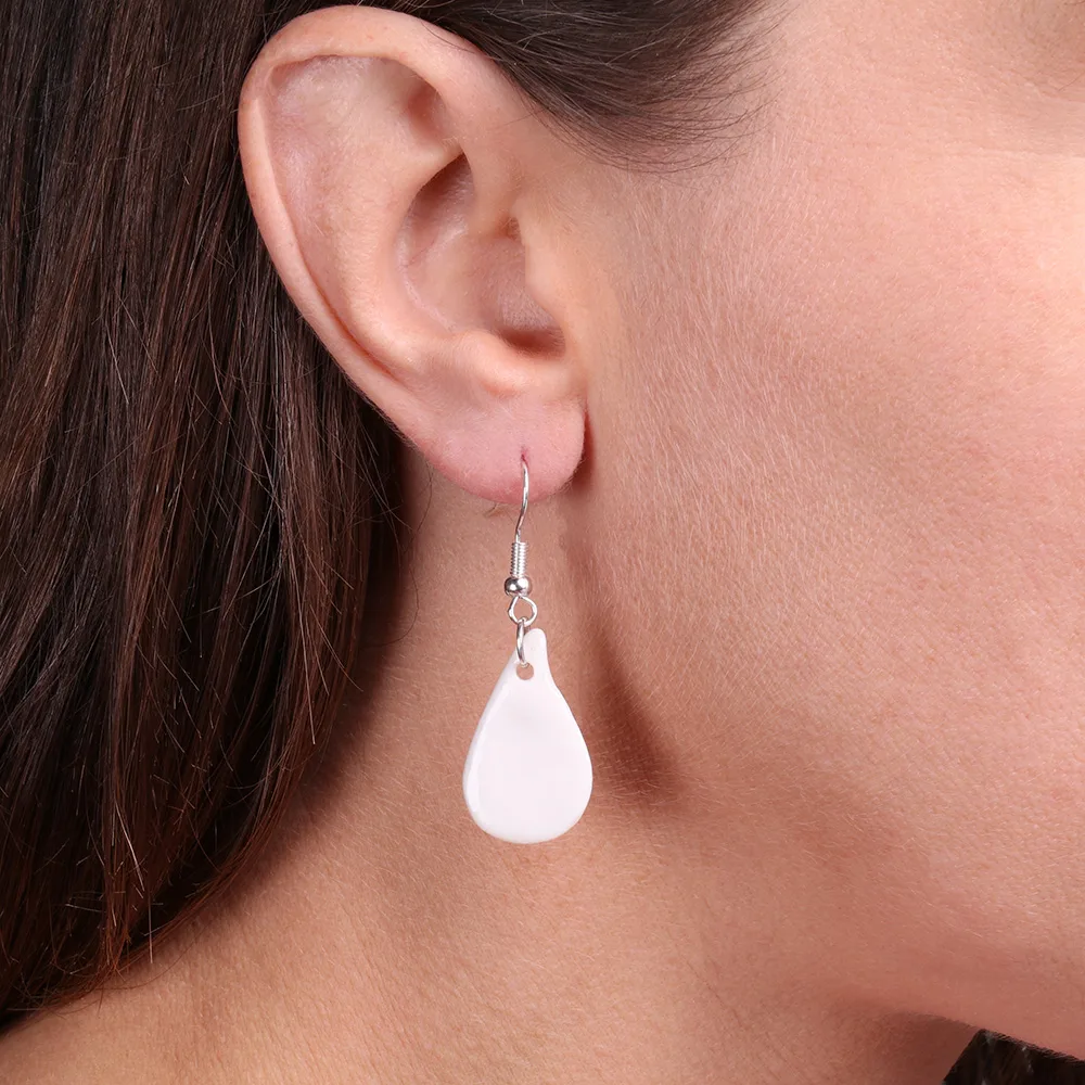 Boucles d’oreilles goutte en porcelaine blanche faites main, élégantes et légères, présentées en vue d’ensemble.