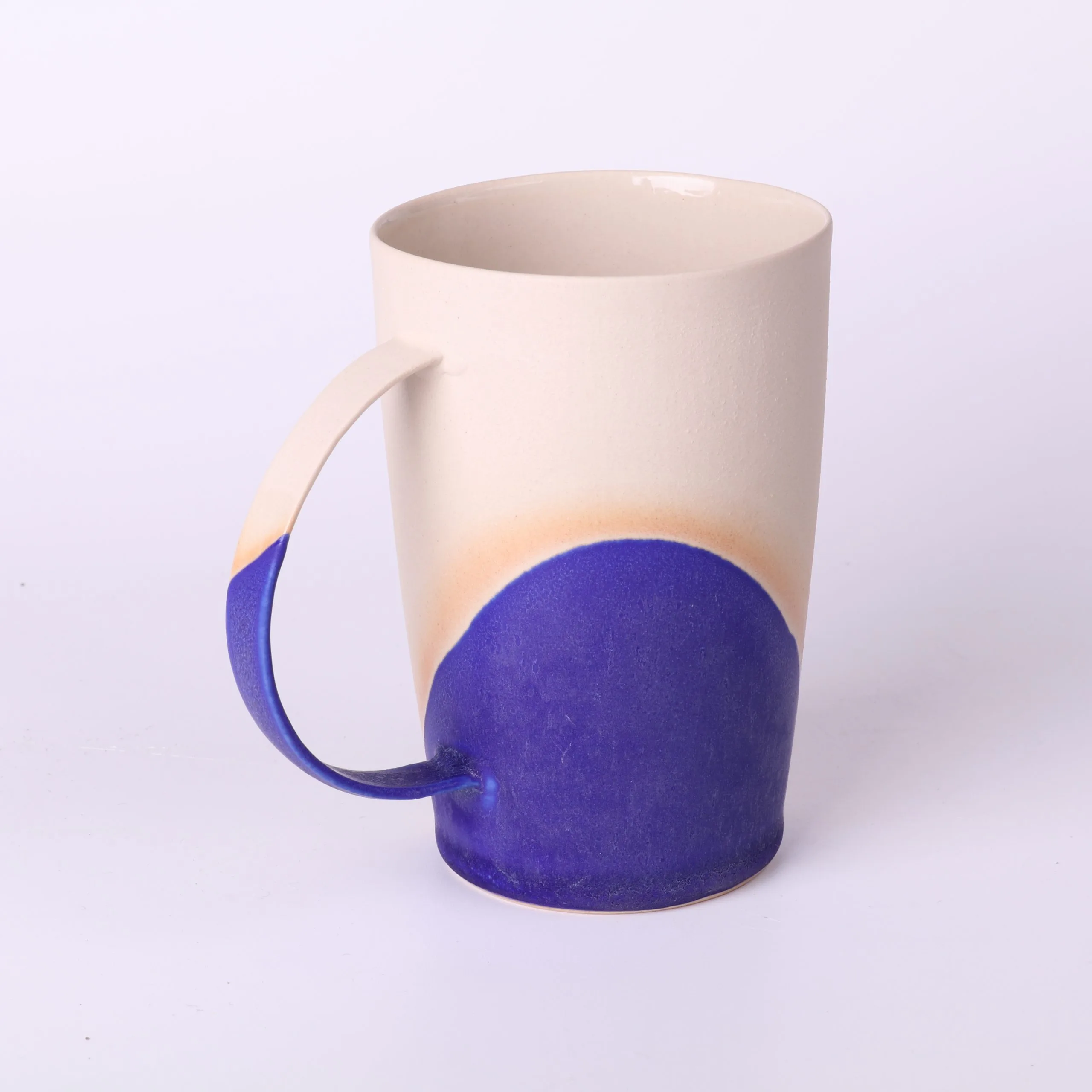 Mug poterie artisanale Bleu Klein — vue de profil Mug poterie artisanale en grès, émail Bleu Klein — vue de profil avec anse fine et hémicycle d’émail.