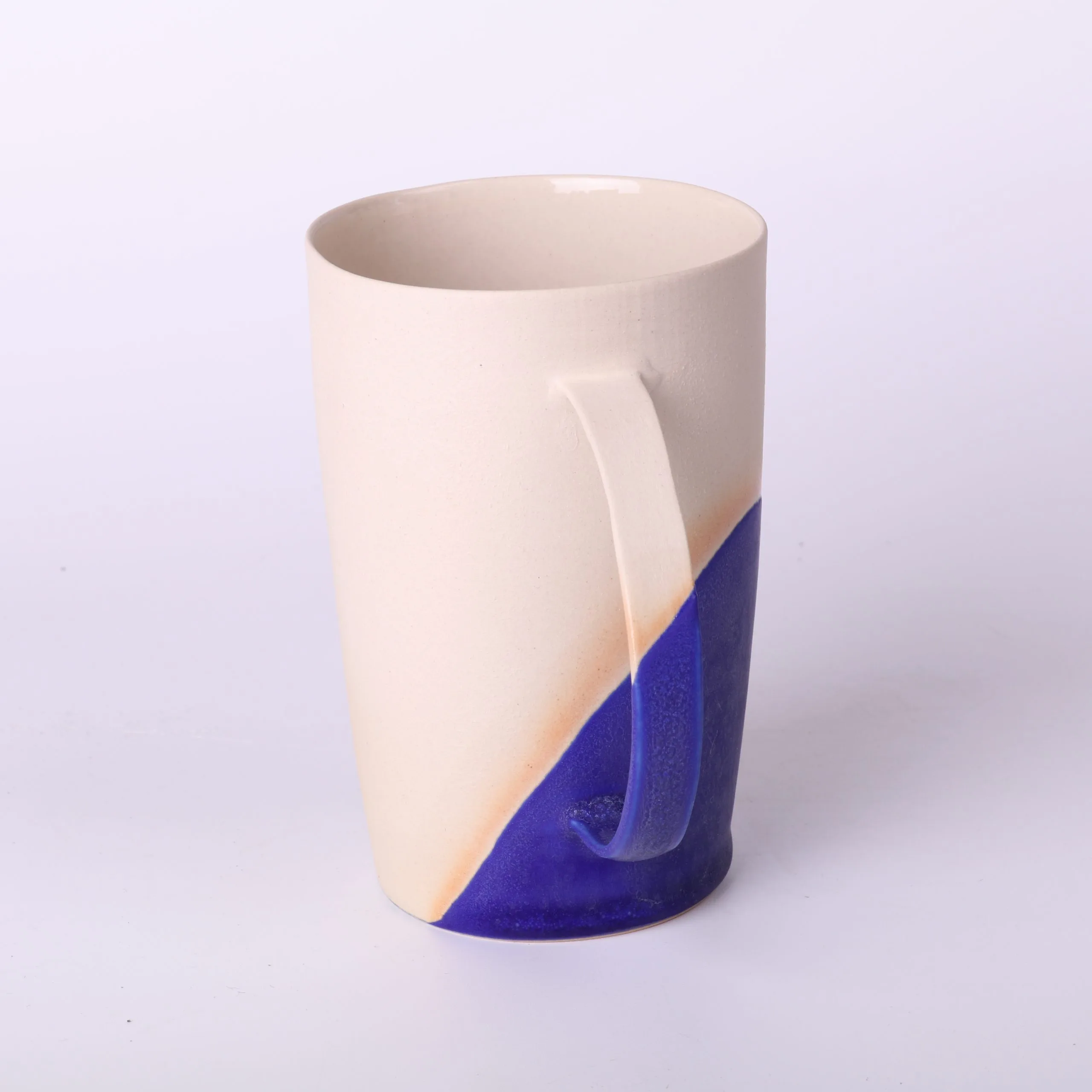 Mug poterie artisanale Bleu Klein — vue arrière, diagonale d’émail Mug poterie artisanale en grès, 330 ml — vue arrière montrant la diagonale d’émail Bleu Klein et l’anse élancée.