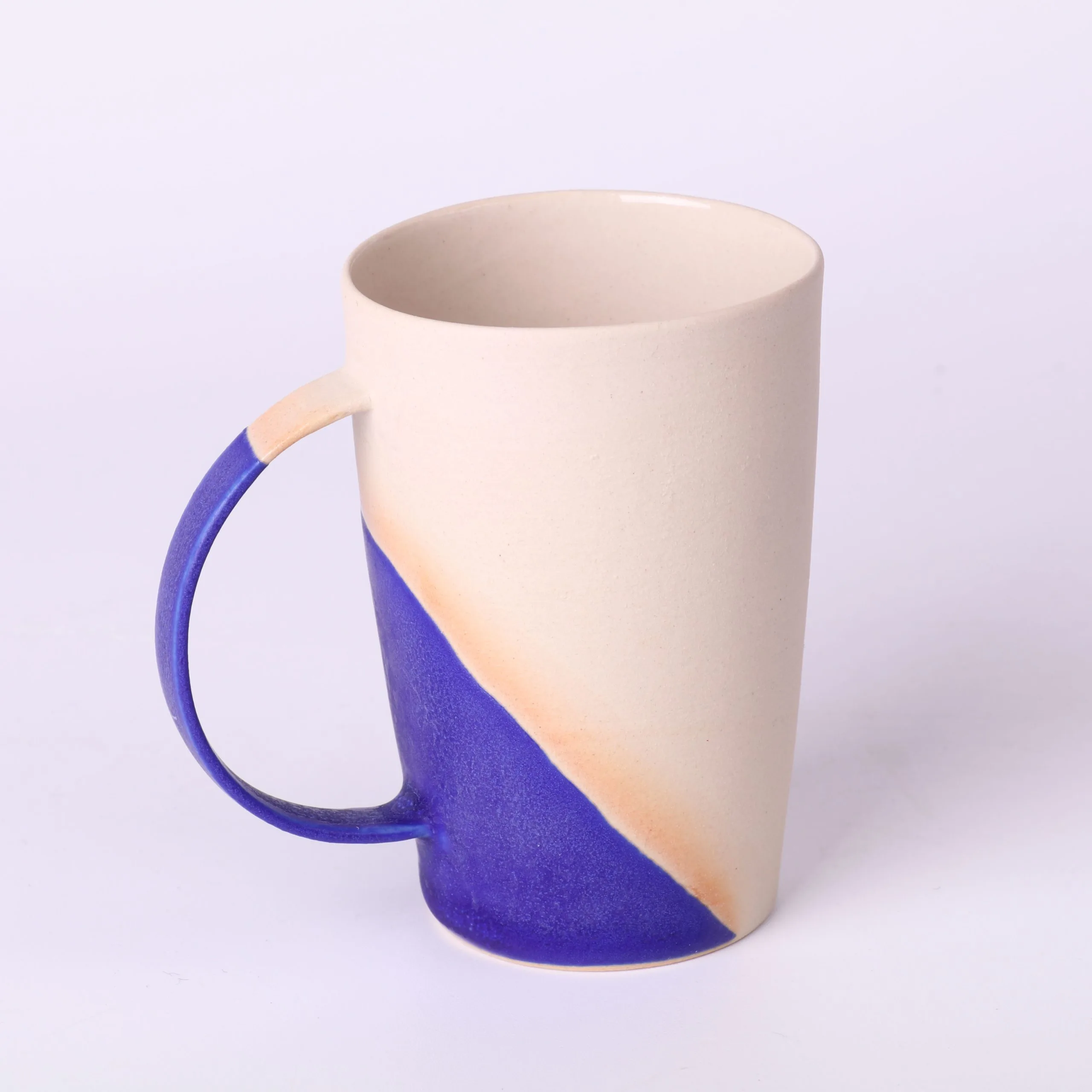 Tasse expresso design Bleu Klein — vue 3/4 Tasse expresso design Bleu Klein — vue trois-quarts, anse courbe, base émaillée, style minimal.