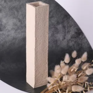 Vase rectangulaire en céramique beige avec texture brute, accompagné de fleurs séchées claires.
